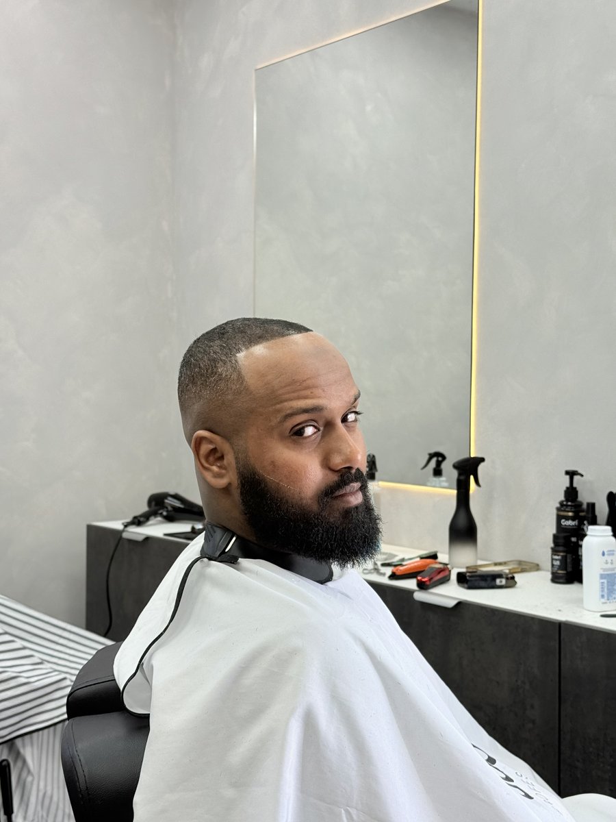 Skin fade with sharp line-up and sculpted beard at Legacy Barbershop Milton Keynes